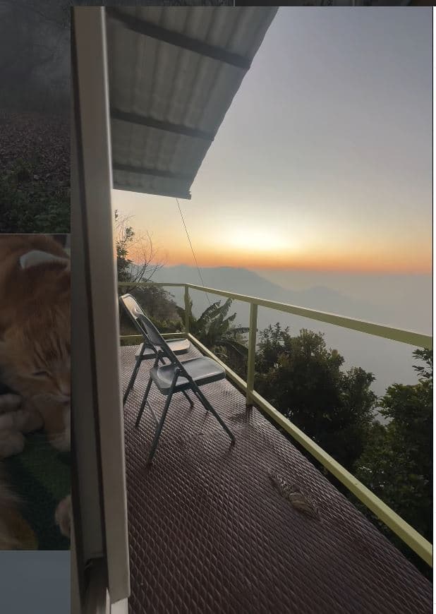 A single chair on a balcony above the valley as the sun goes down