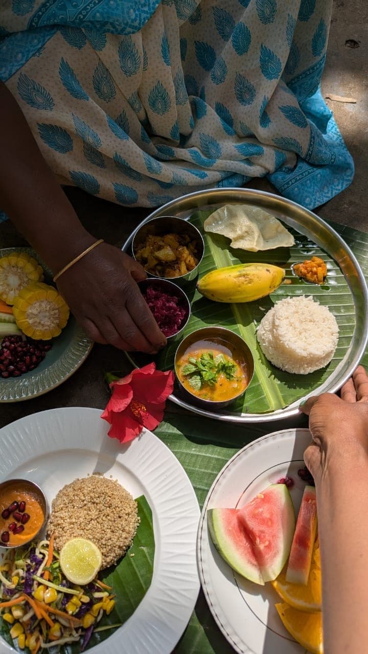 Food being served onto a banana leaf by hand