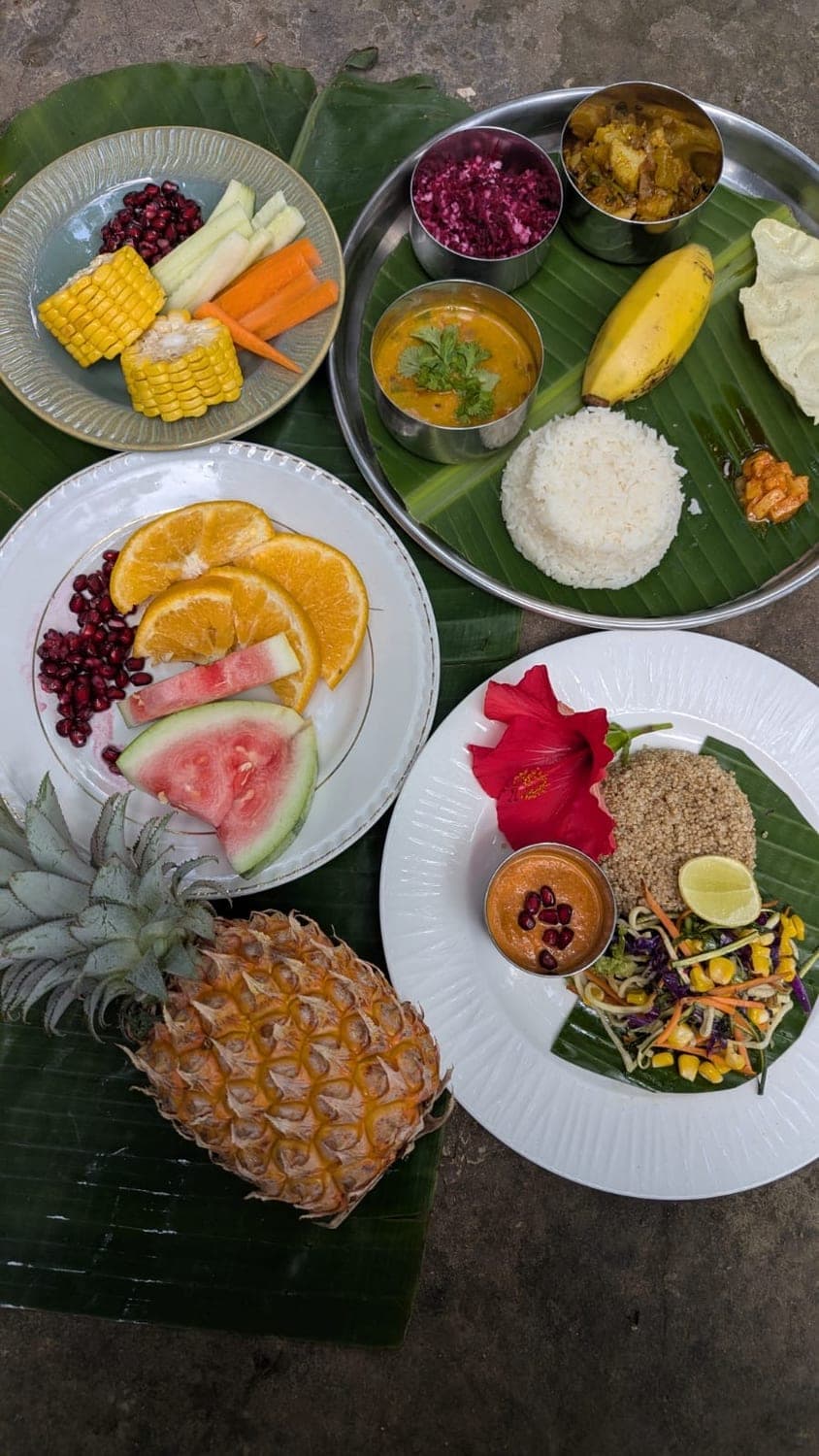 A spread of rice, curries and fresh fruit with a pineapple
