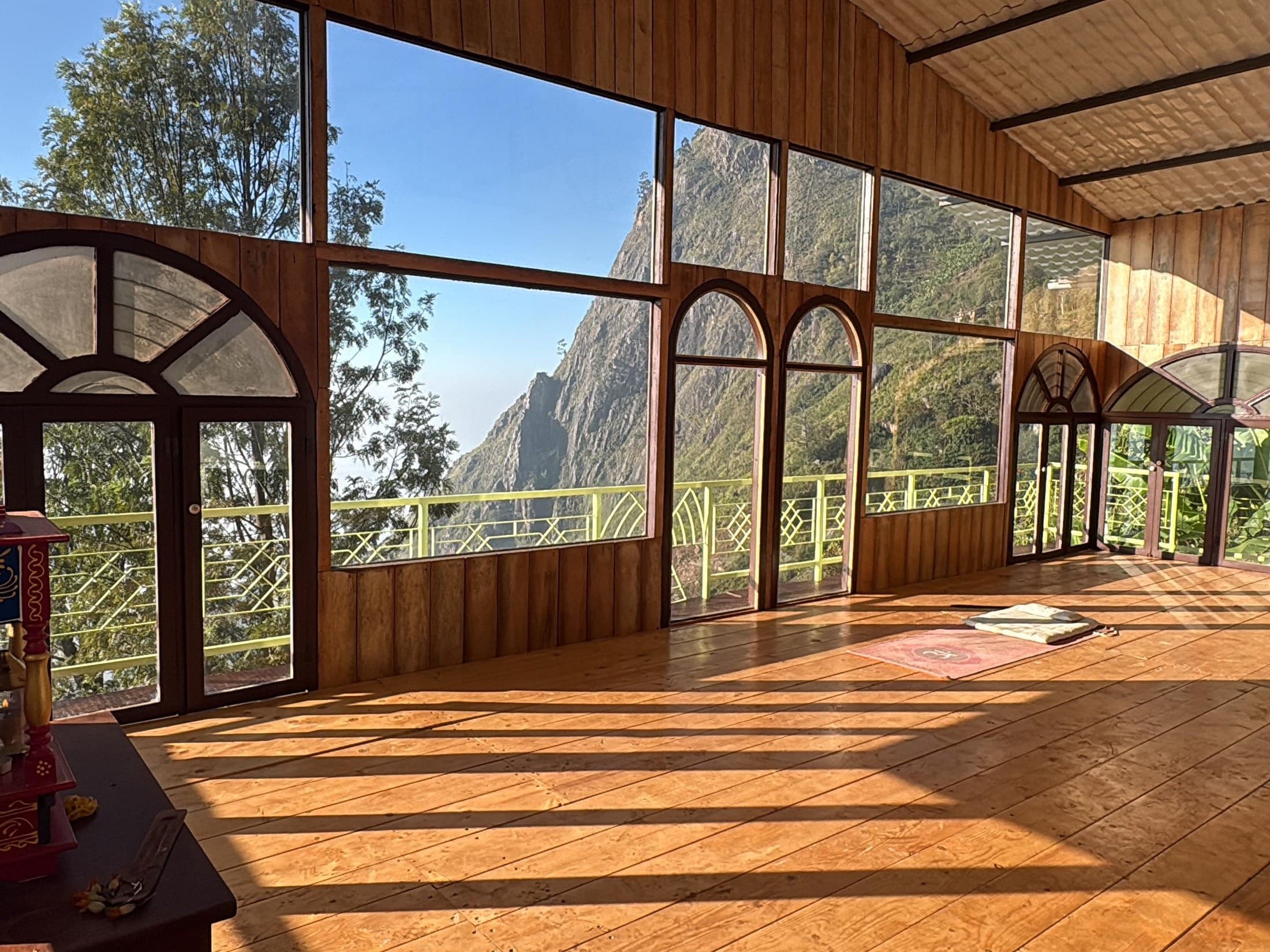 Mountain peaks framed through the wide windows of the yoga hall
