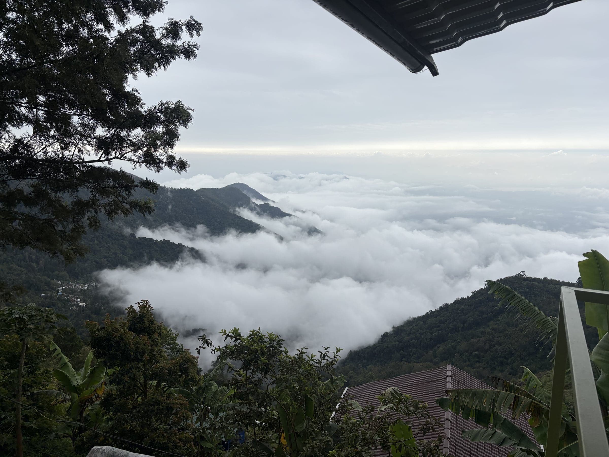 A sea of cloud filling the valley below the cottages at dawn